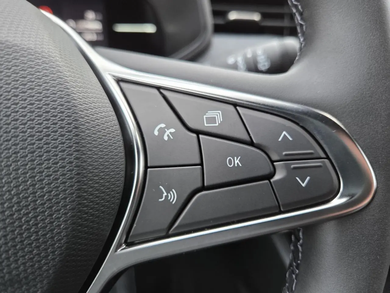 Gros plan sur les commandes multifonctions à droite du volant de la Renault Clio V gris schiste métallisé.