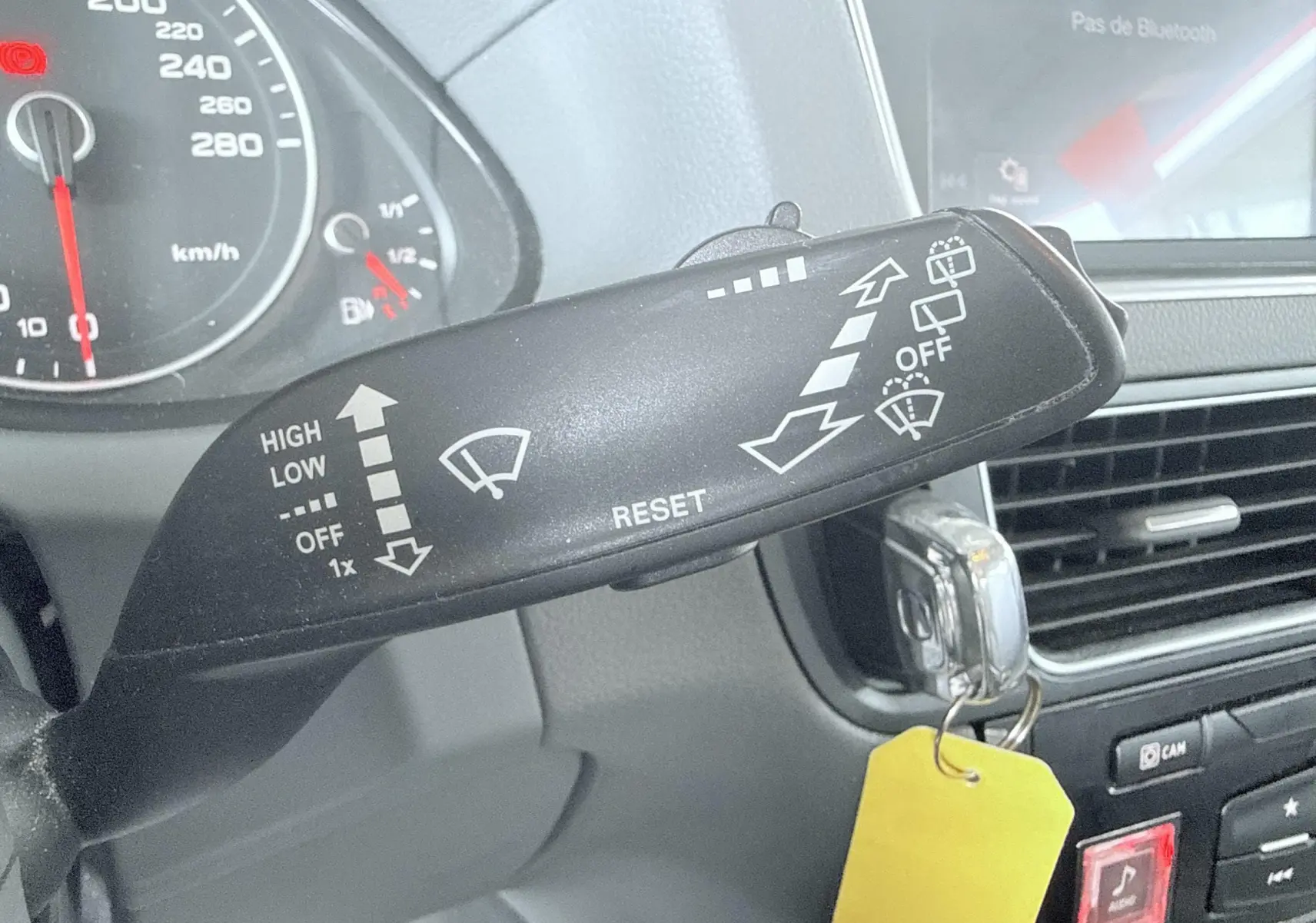 Gros plan sur la manette d'essuie-glace côté gauche du tableau de bord d'un Audi Q5 noir de 2014.