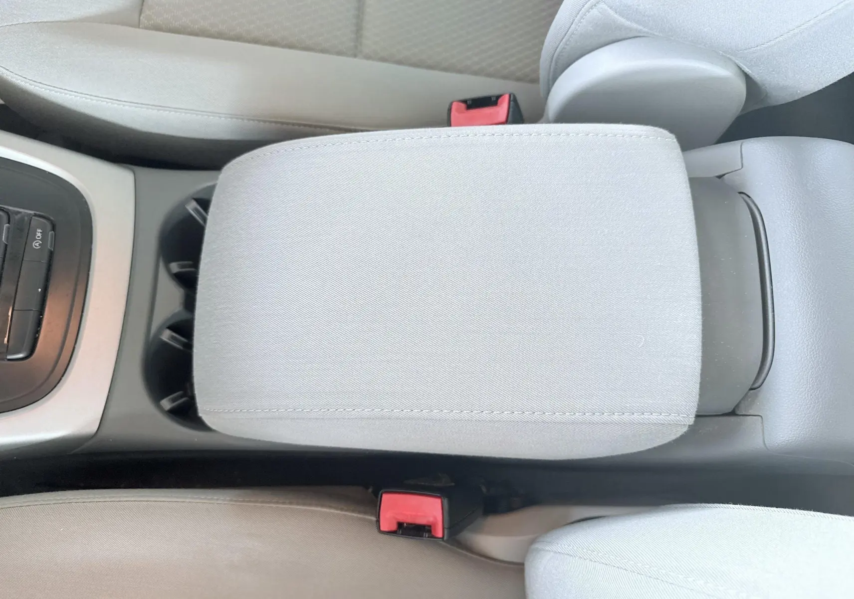 Gros plan sur l'accoudoir central gris clair et les ceintures de sécurité rouges de l'Audi Q5 2014 noir.