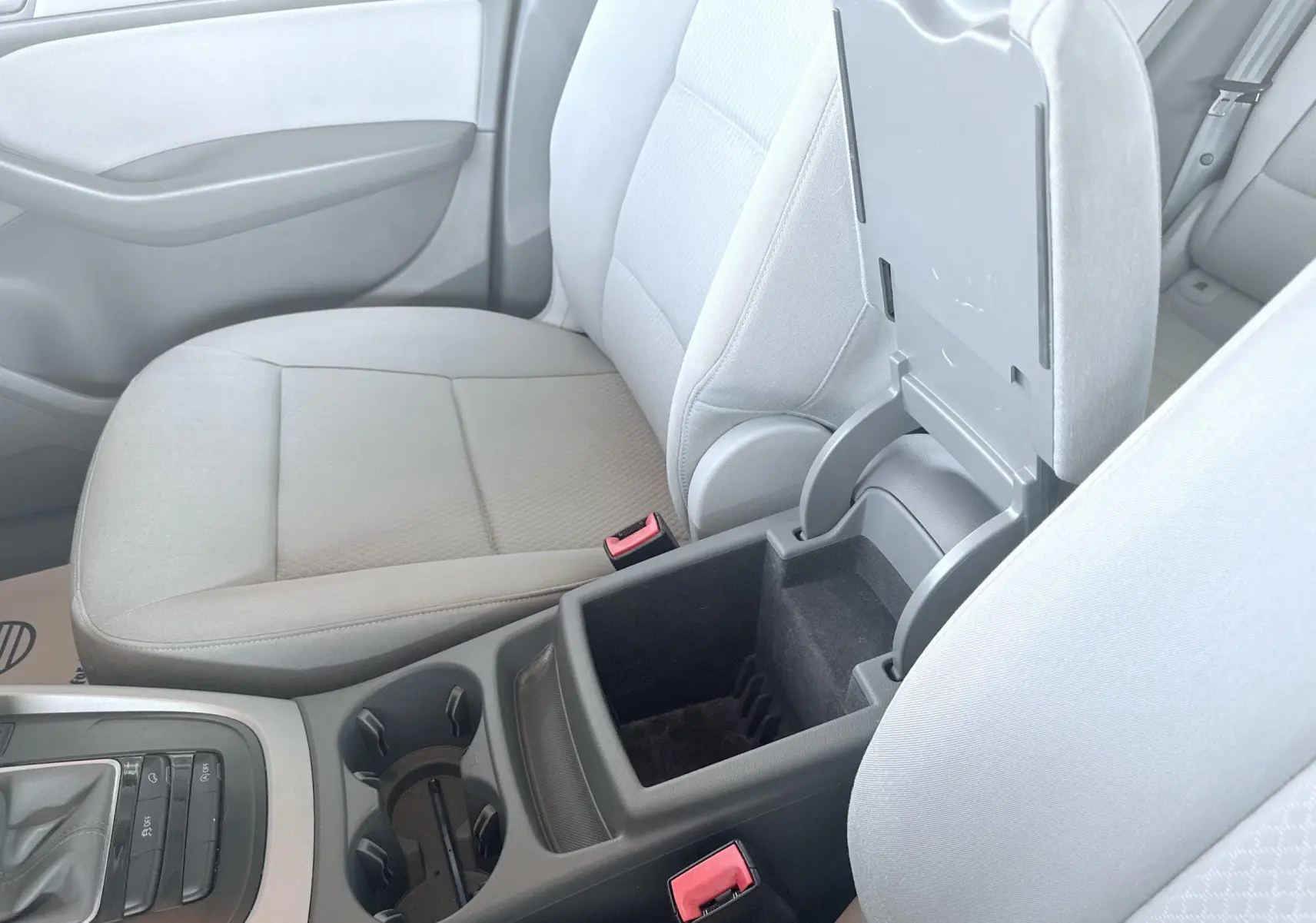 Vue intérieure centrée sur la console centrale ouverte et les sièges avant gris clair d’un Audi Q5 noir de 2014.