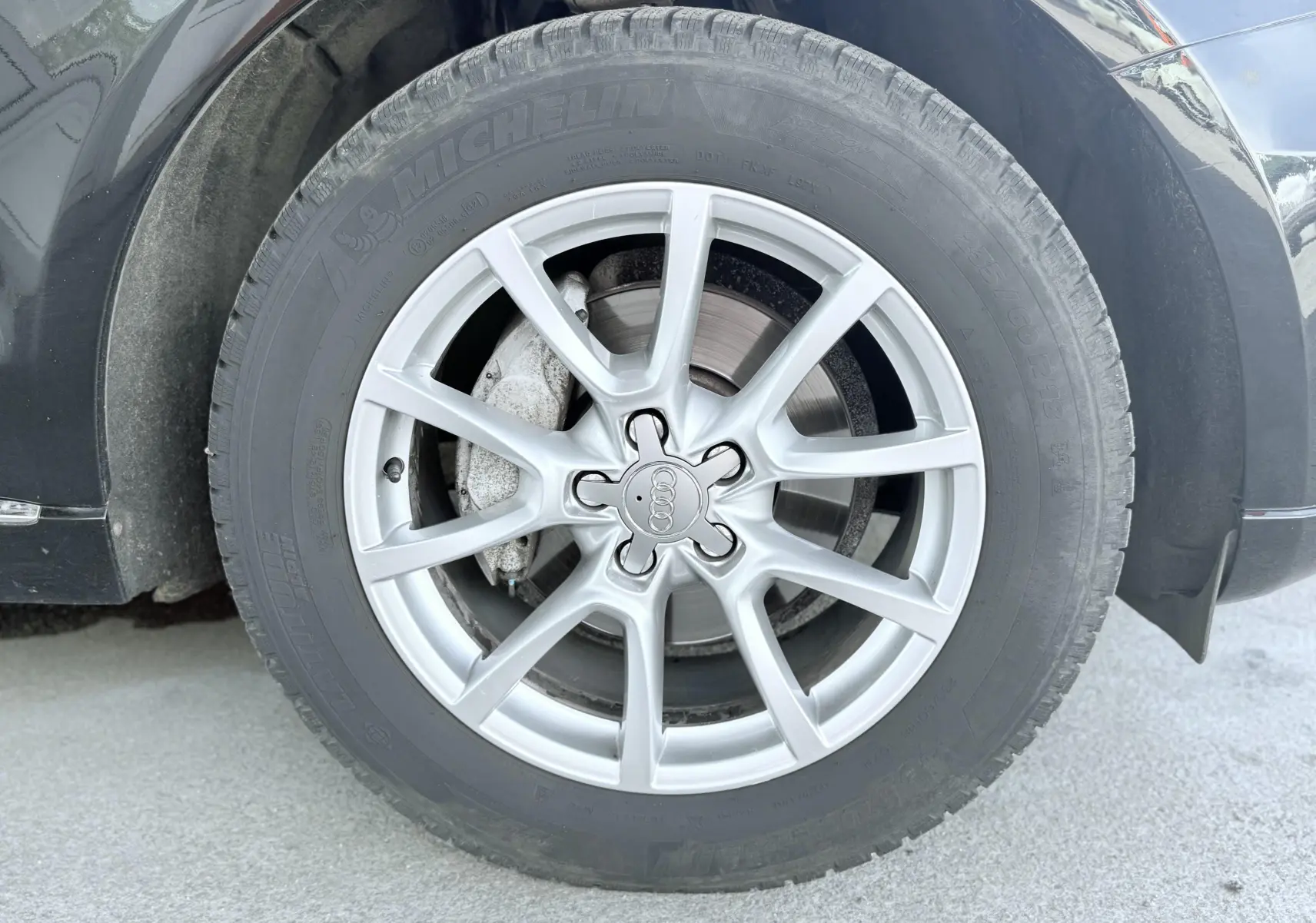 Gros plan sur la roue avant gauche avec jante argentée et pneu Michelin du SUV Audi Q5 noir.