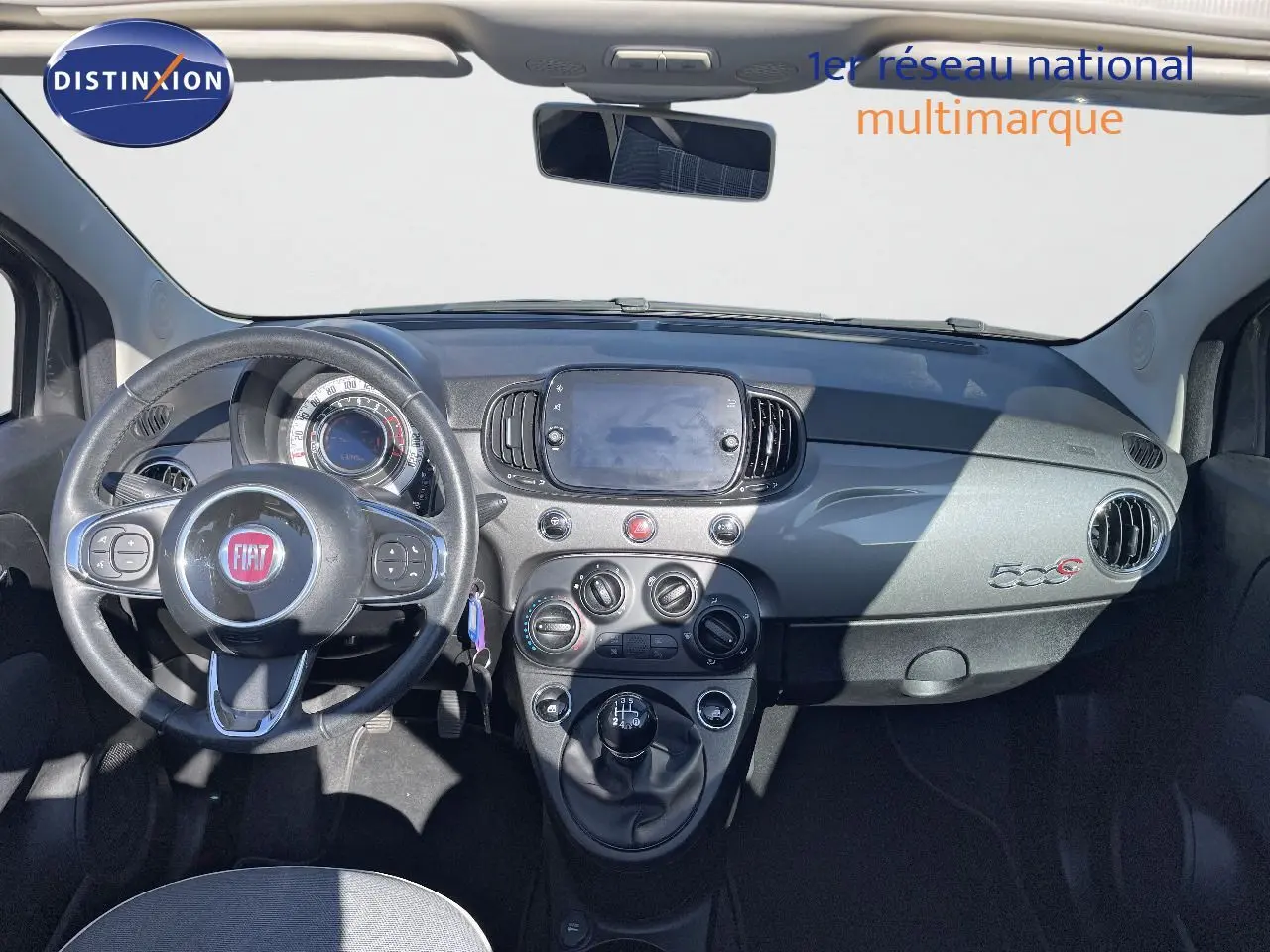 Intérieur avant de la Fiat 500C grise, tableau de bord avec volant, commandes manuelles et écran central tactile.