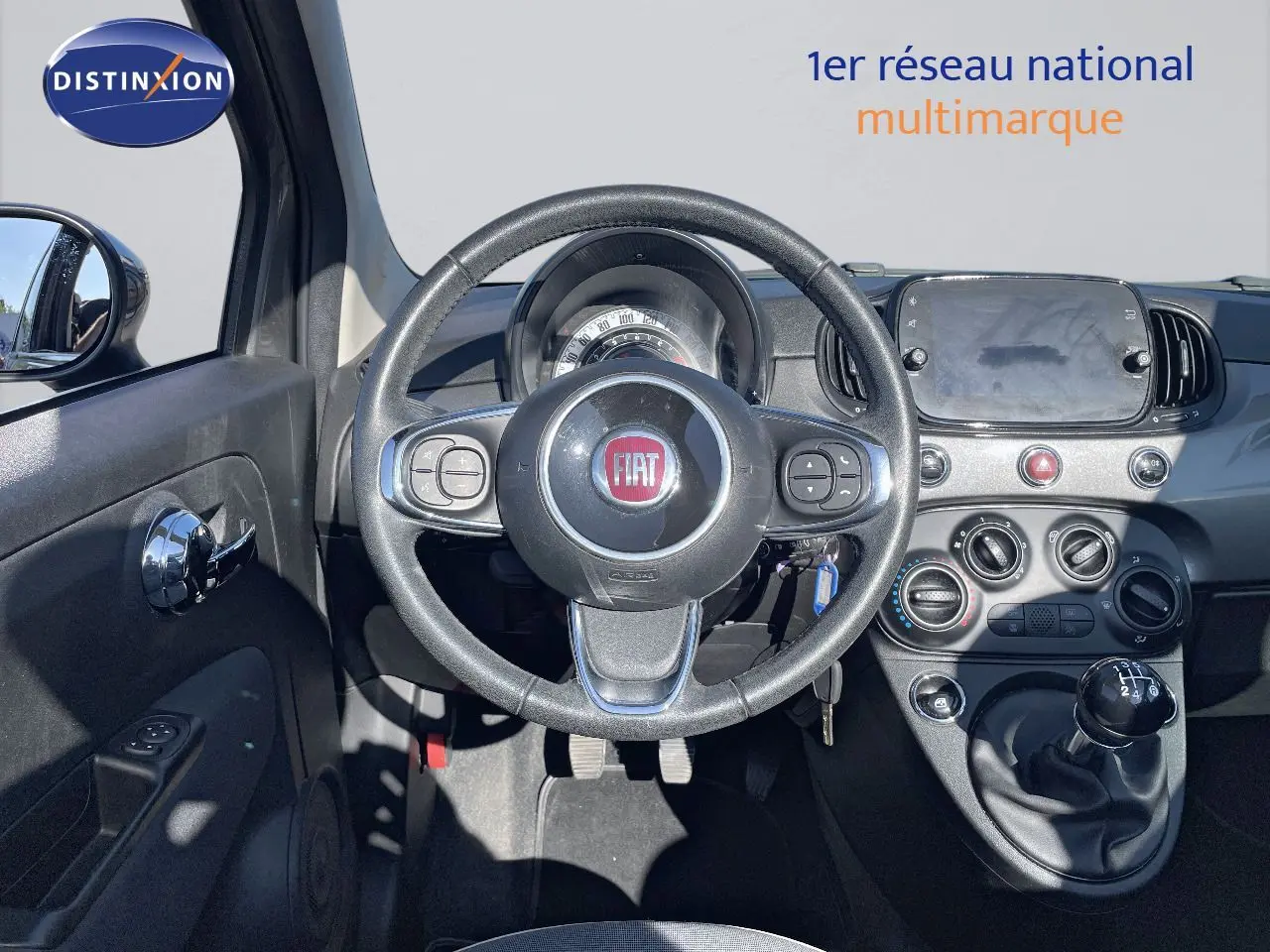 Vue intérieure du tableau de bord et volant d'une Fiat 500C 2019 avec boîte manuelle et finitions noires.