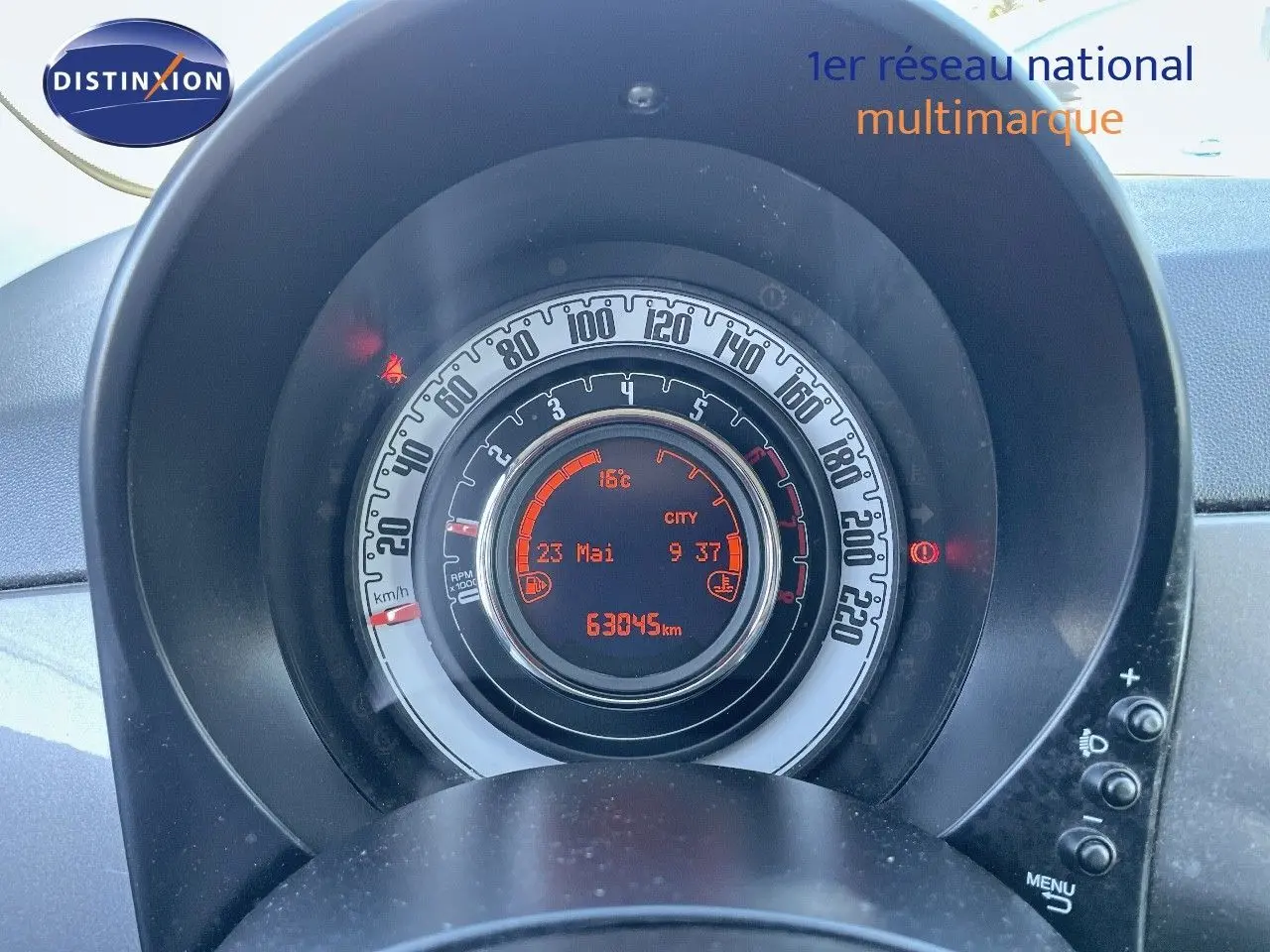 Vue rapprochée du tableau de bord de la Fiat 500C gris électroclash, affichant le compteur et l'ordinateur de bord digital.