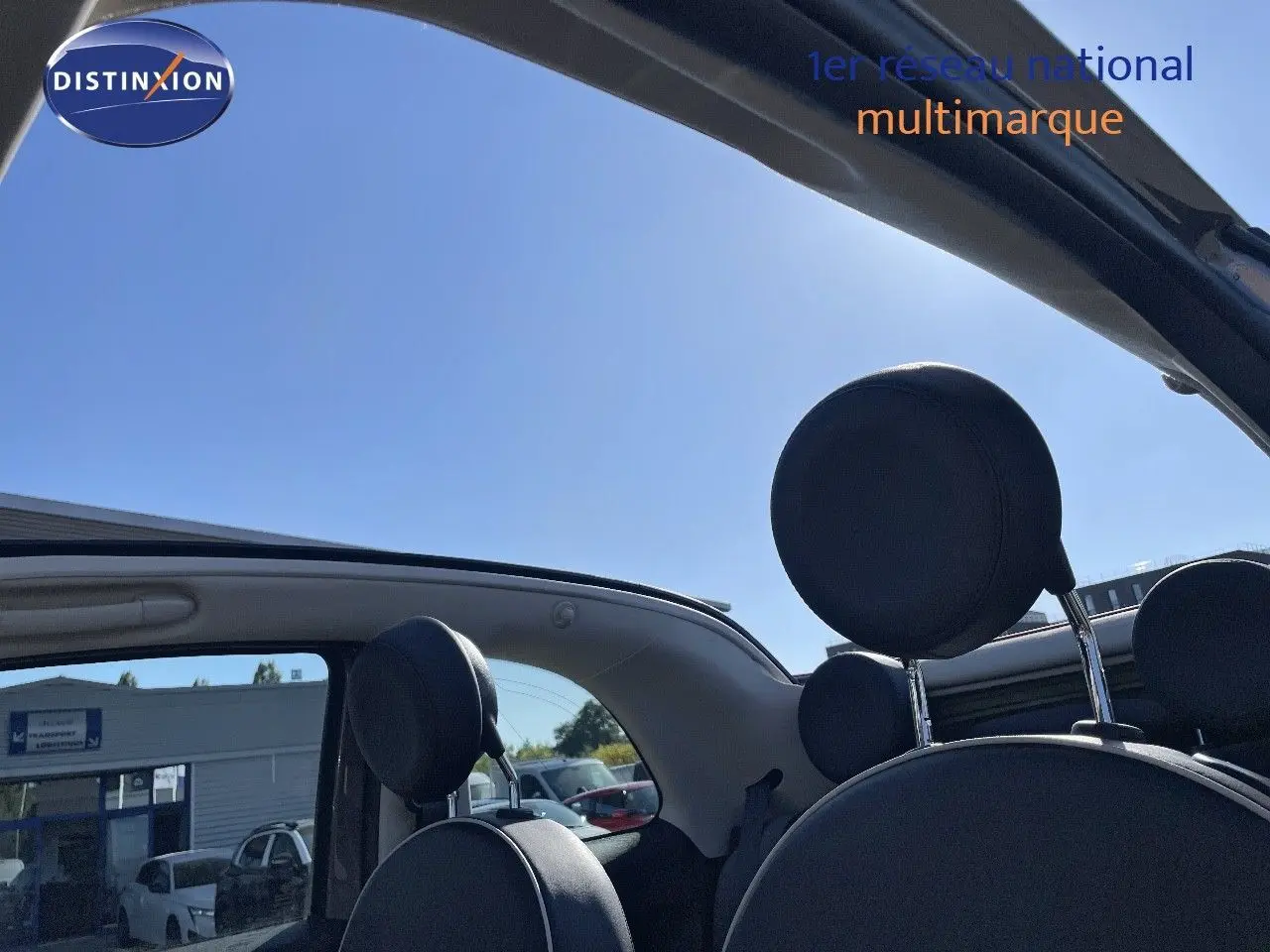 Vue intérieure arrière de la FIAT 500C grise électroclash, toit ouvert et appuie-têtes noirs visibles.