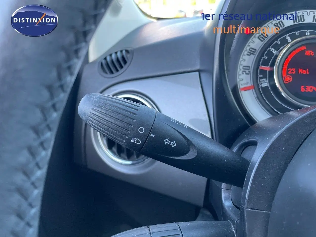 Gros plan sur la commande des clignotants et le tableau de bord gris d'une Fiat 500C 2019 vue côté gauche.