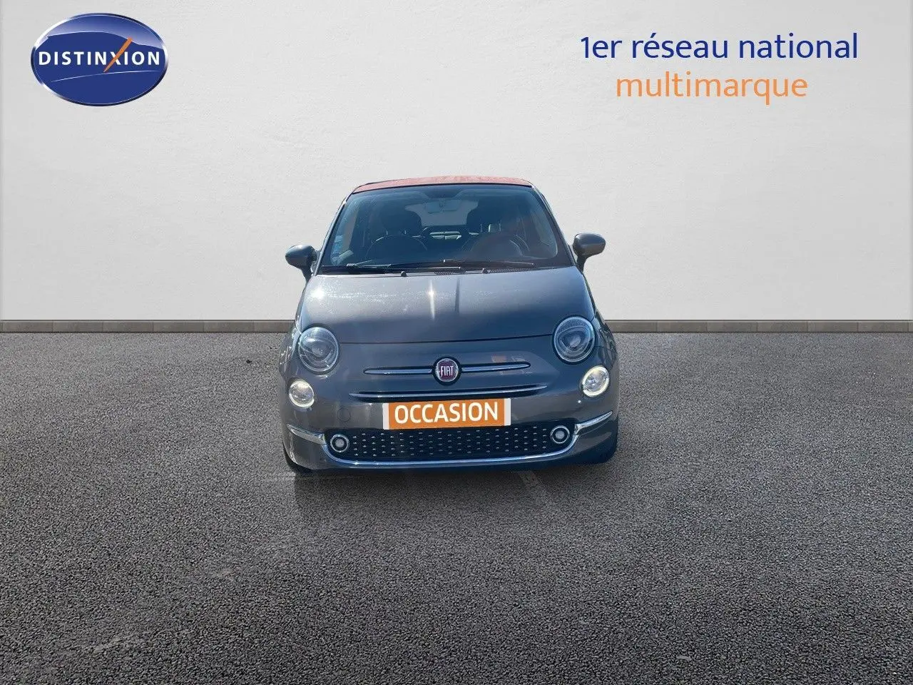 Vue frontale d'une FIAT 500C grise Electroclash avec toit rouge, sur fond neutre en extérieur.