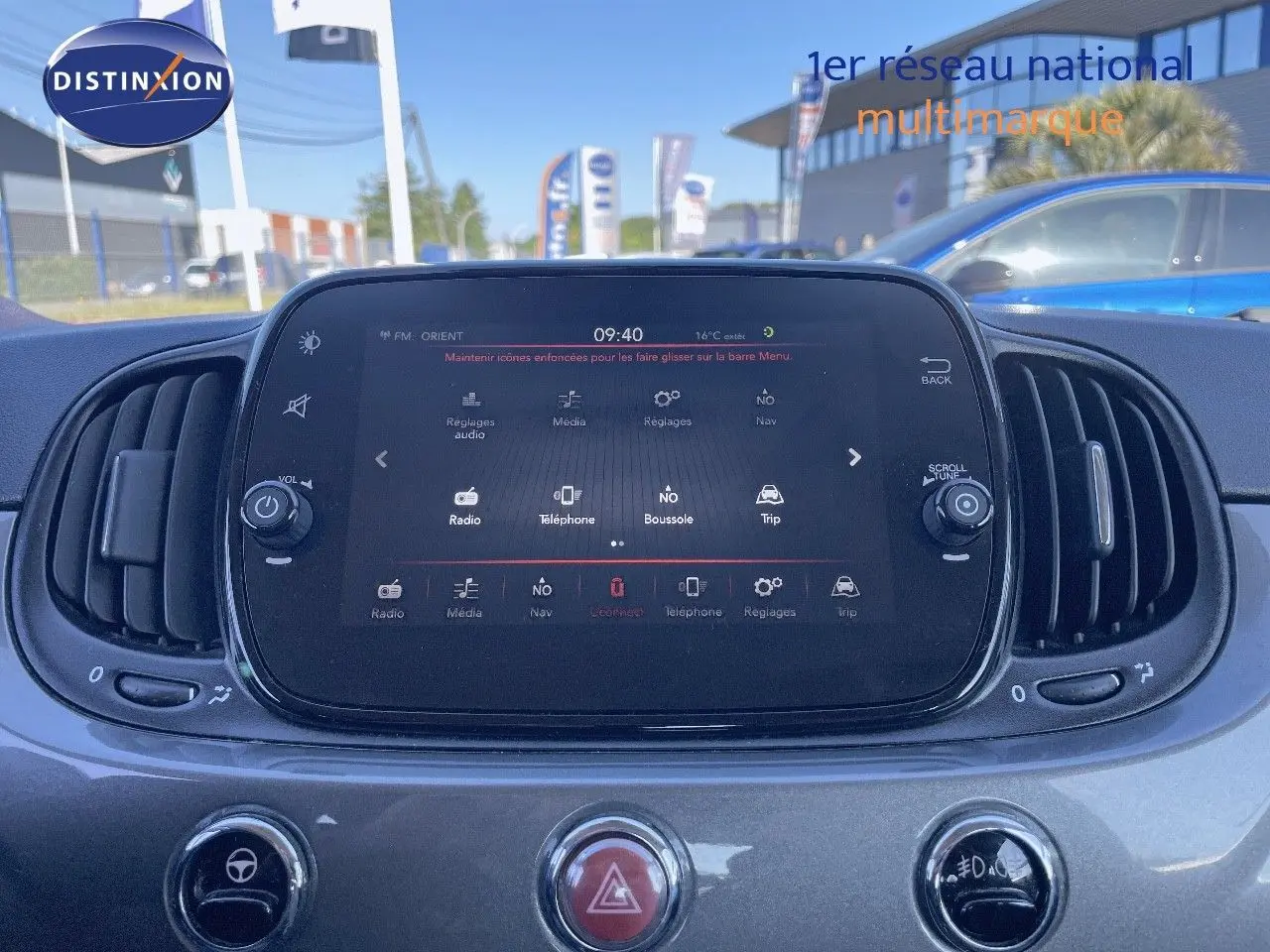 Écran tactile central du tableau de bord d'une Fiat 500C gris électroclash, avec commandes d'aération visibles.
