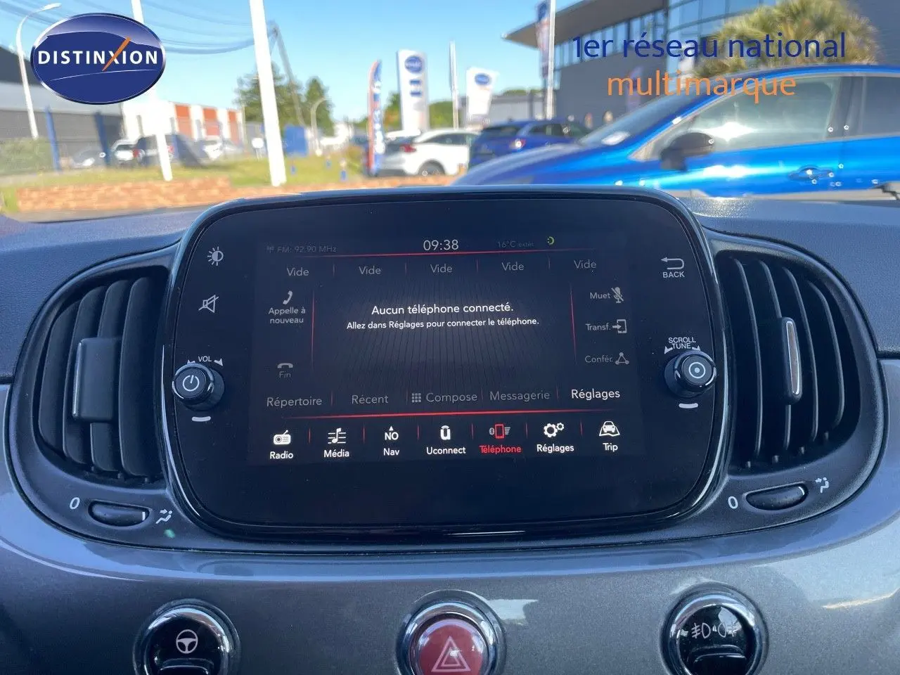 Vue intérieure centrée sur l'écran tactile multimédia de la Fiat 500C gris métallisé, avec commandes et aérateurs visibles.