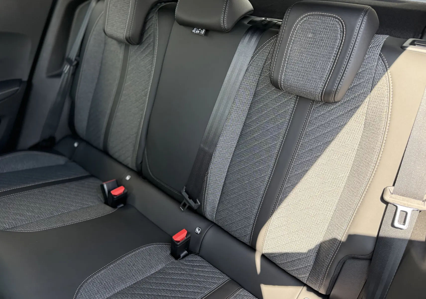 Vue rapprochée des sièges arrière en tissu et cuir gris du Peugeot 2008 Hybrid 145ch Allure 2025.