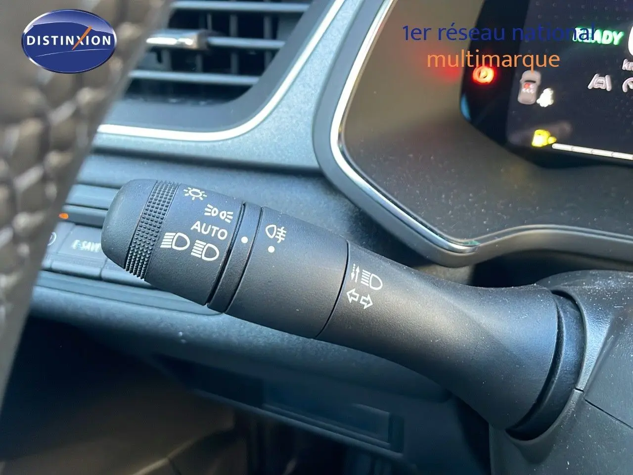 Gros plan sur la commande des feux et clignotants côté gauche du tableau de bord du Renault Captur bleu Iron Metal 2025.