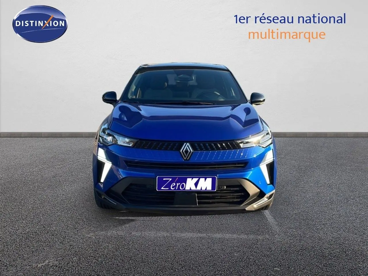 Vue de face d'un Renault Captur E-Tech hybride bleu Iron Metal avec toit noir et feux LED allumés.