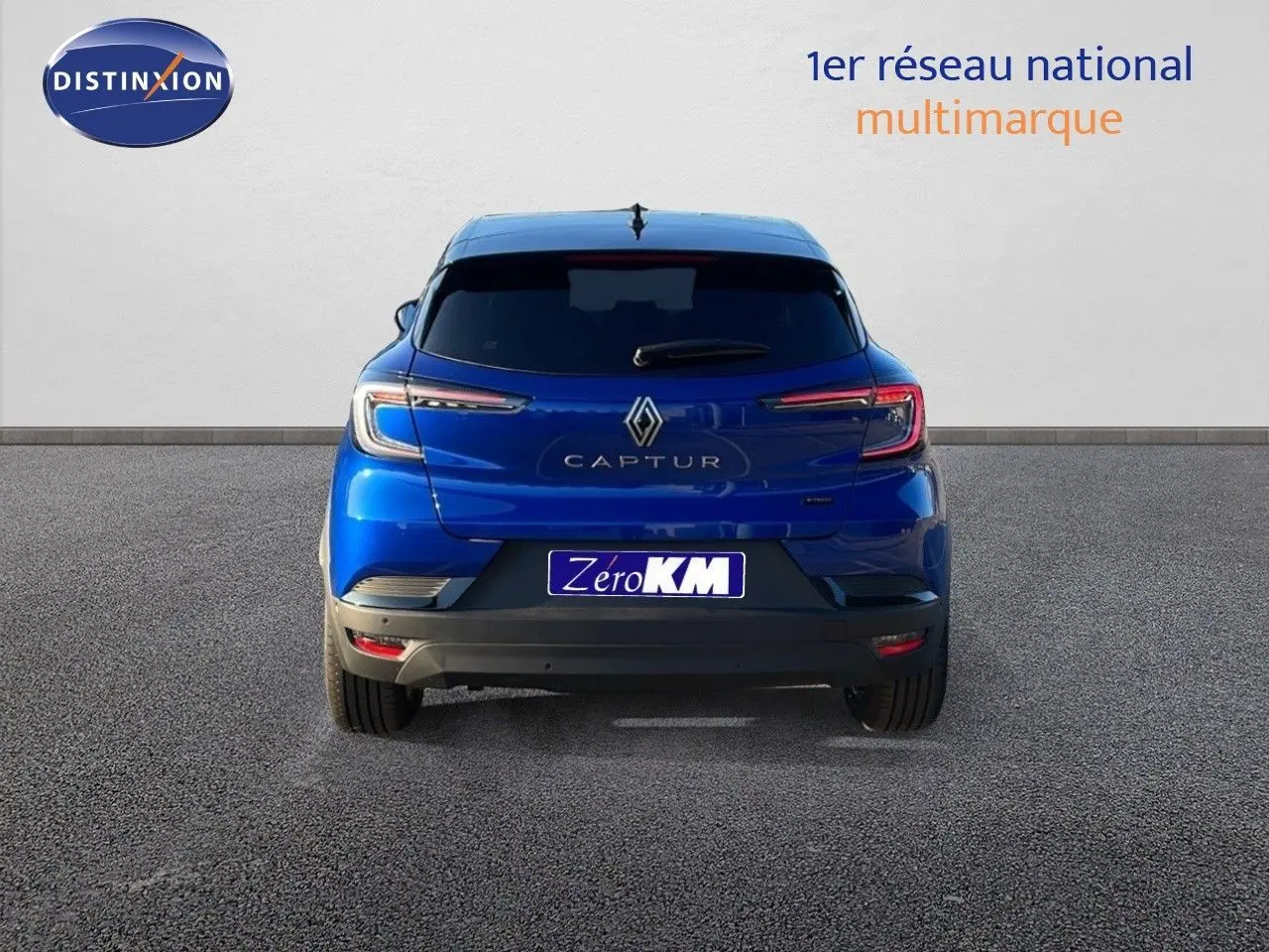 Vue arrière du Renault Captur E-Tech hybride bleu Iron Metal avec toit noir, feux LED et plaque Zero KM visible.
