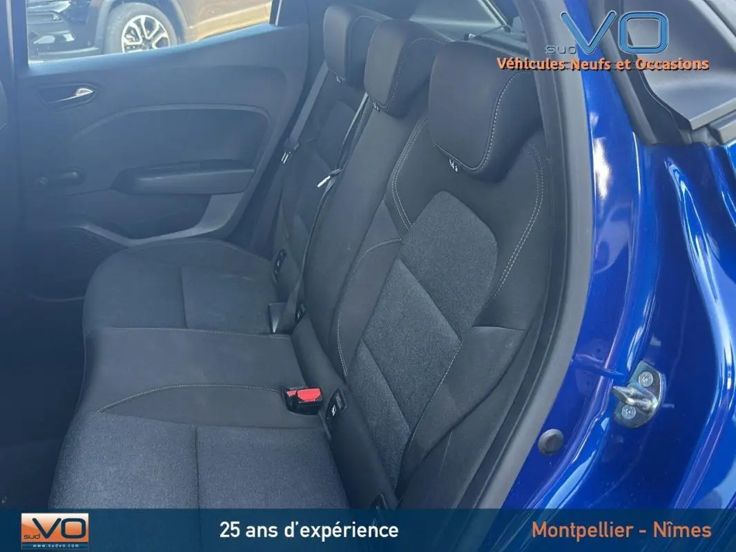 Banquette arrière en tissu noir vue côté droit d'une Renault Clio bleu foncé 2023 avec porte ouverte.