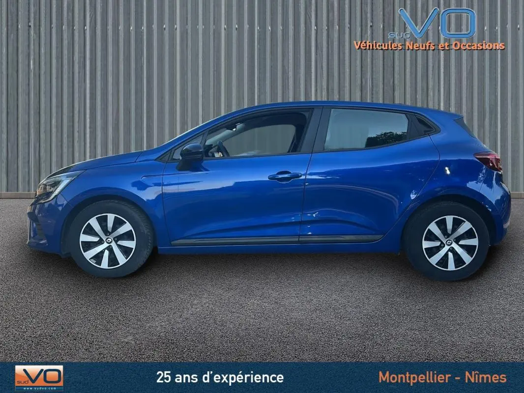 Profil côté gauche d'une Renault Clio V TCe 90 Équilibre bleu foncé 2023 avec jantes et poignées assorties.