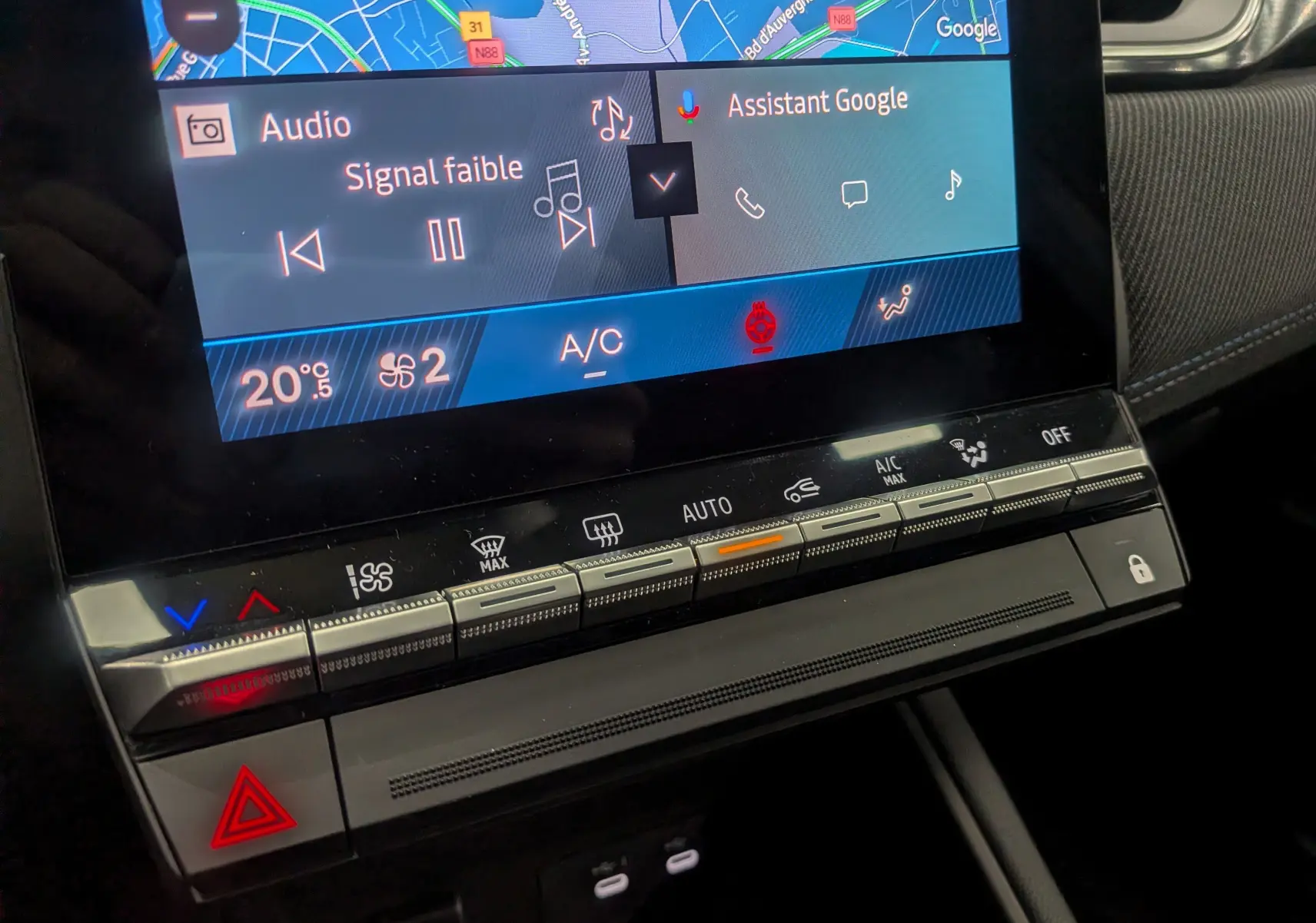 Gros plan sur l’écran tactile et la console centrale du Renault Symbioz E-TECH gris, affichant la climatisation et l’interface multimédia.
