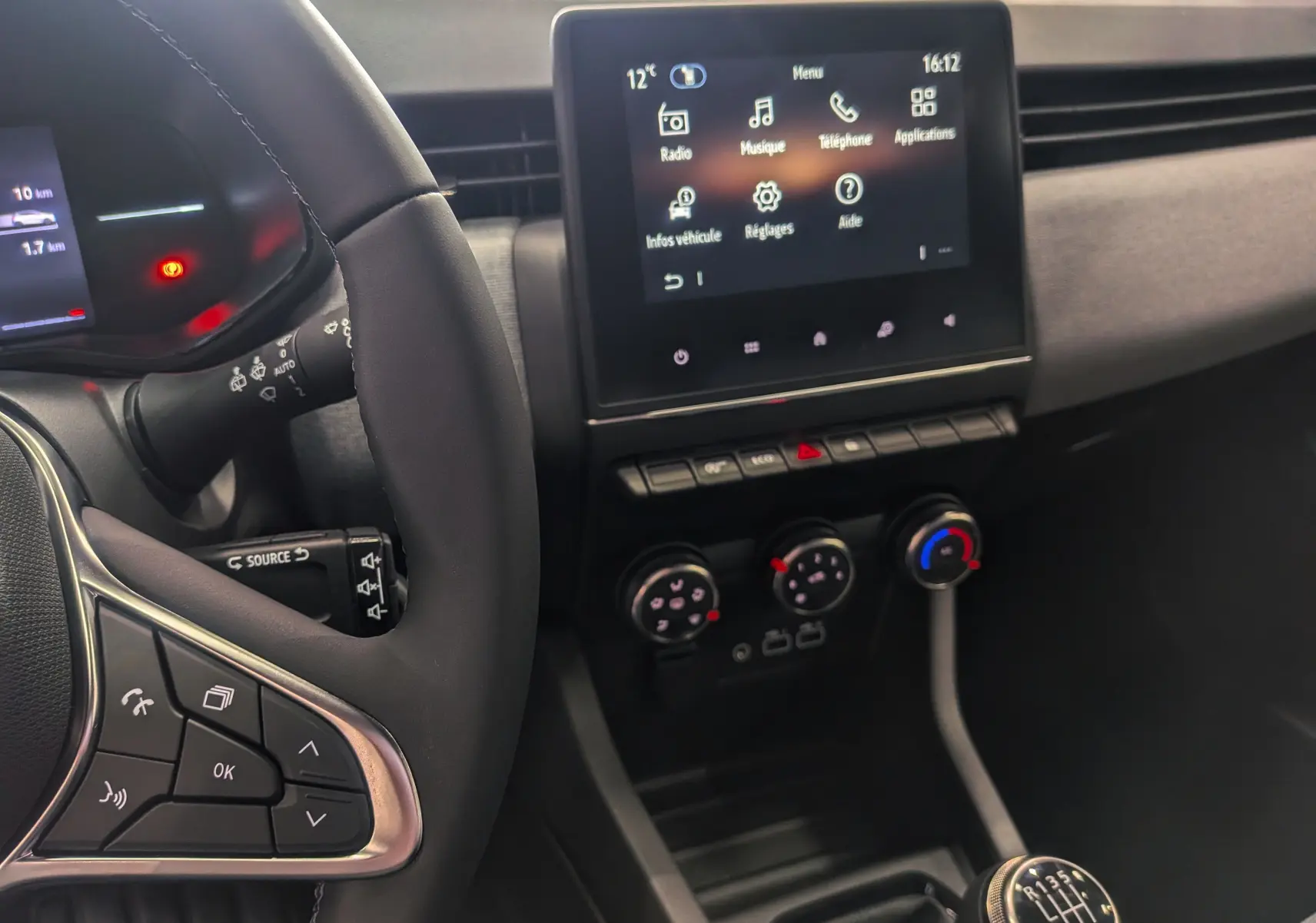 Vue intérieure de la Renault Clio V Blue dCi 100 Evolution montrant le volant, l’écran tactile et la commande de boîte manuelle.