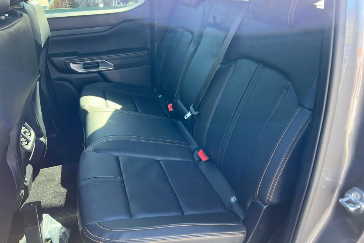 Vue intérieure arrière côté droit du Ford Ranger 2025 gris carbone, sièges cuir noirs avec surpiqûres contrastantes.