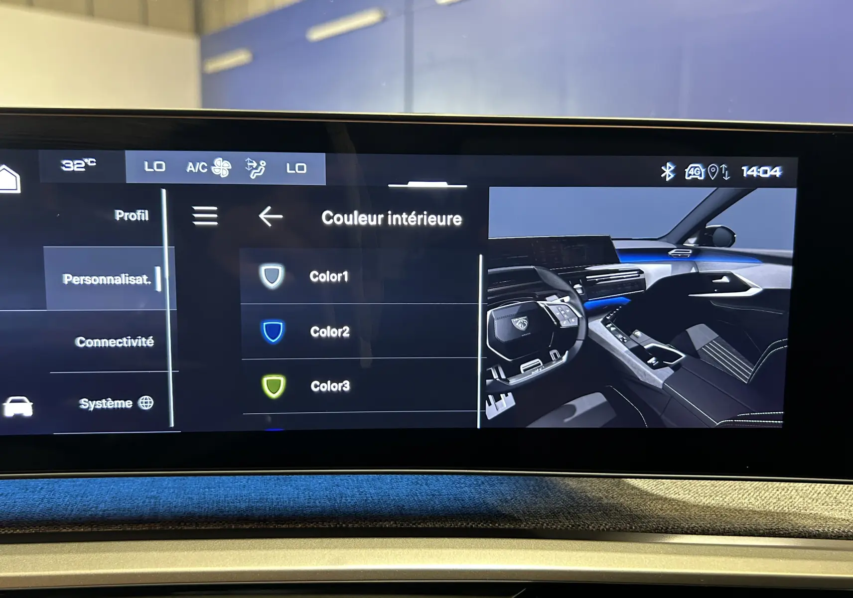 Écran tactile du tableau de bord du Peugeot 3008 Hybrid 2024 montrant les options de couleur intérieure avec vue du poste de conduite.