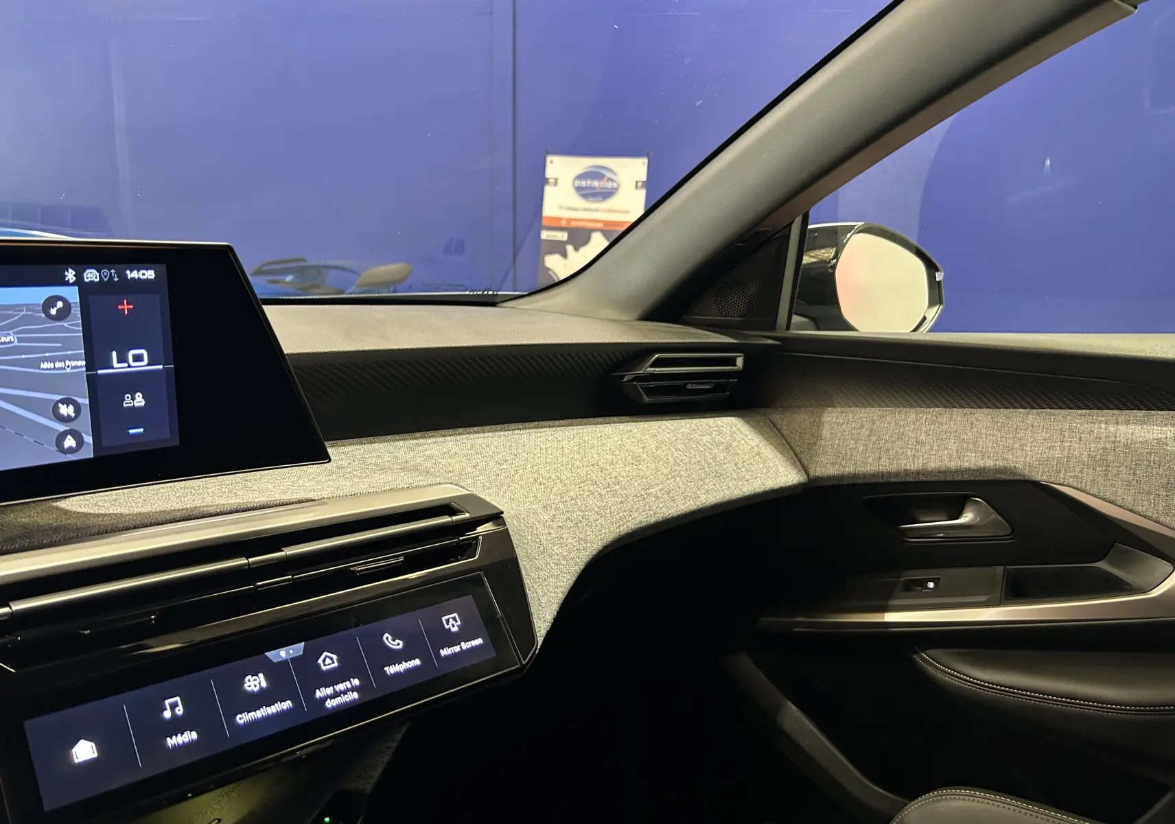 Vue intérieure côté passager du Peugeot 3008 Hybrid 2024, avec tableau de bord moderne et habillage tissu gris.