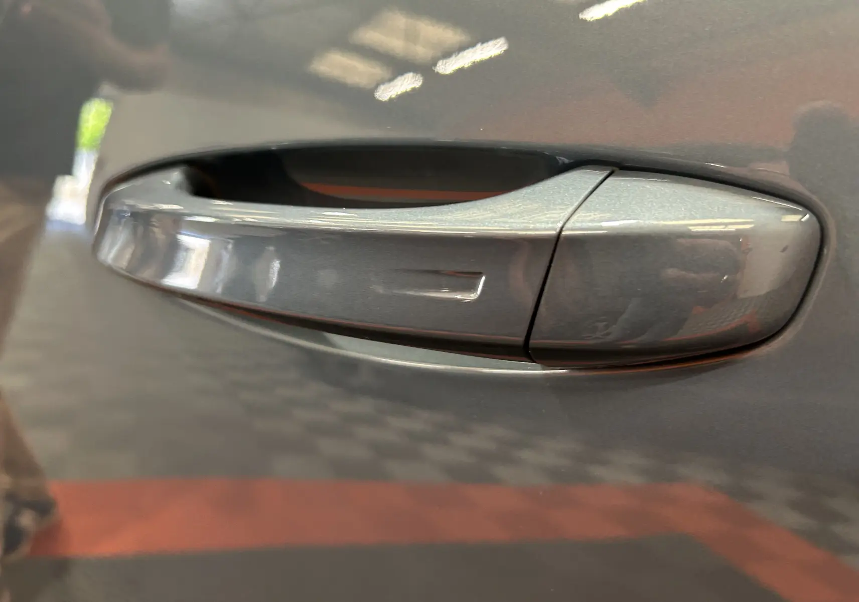 Poignée de porte côté gauche du Peugeot 3008 III Hybrid 136 e-DCS6 Allure en bleu Ingaro, vue en gros plan.