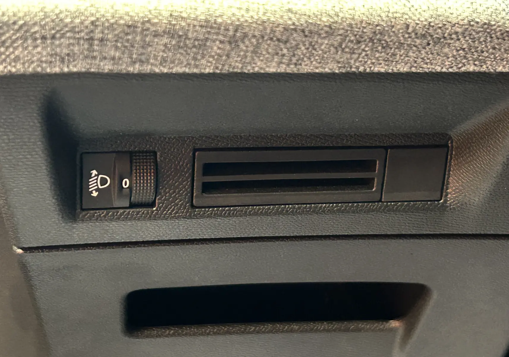 Réglage de hauteur des phares et prise d'air sur panneau intérieur noir d'un Peugeot 3008 2024.