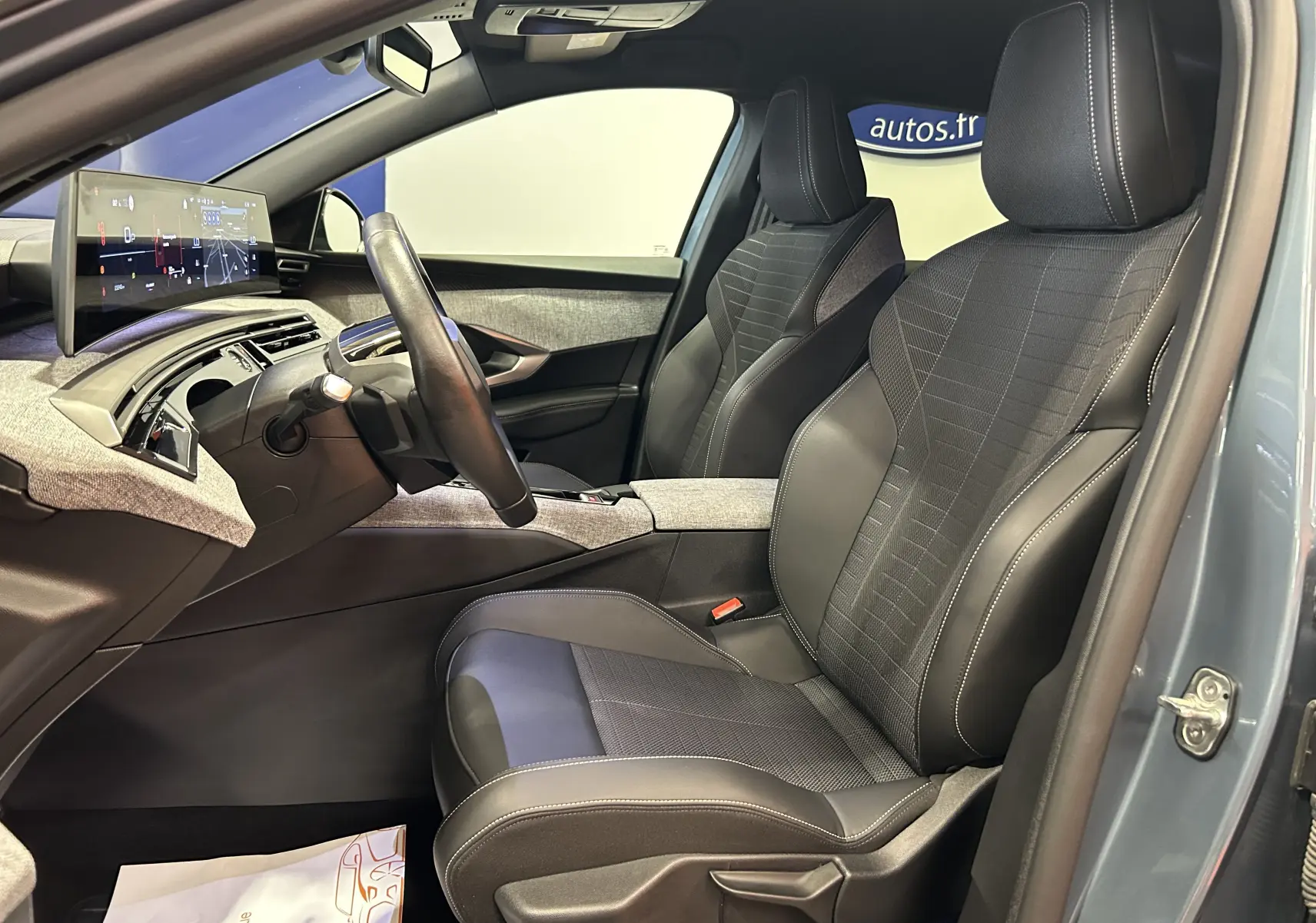 Vue intérieure côté conducteur du Peugeot 3008 Hybrid 2024 Bleu Ingaro, avec sièges en cuir et tableau de bord numérique panoramique.