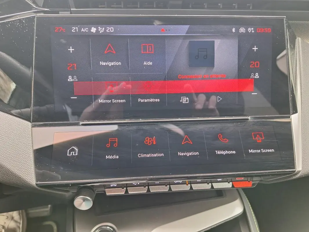 Vue rapprochée de l’écran tactile central du Peugeot 308 Hybrid 145 e-DCS6 GT gris, affichant les menus de navigation et climatisation.