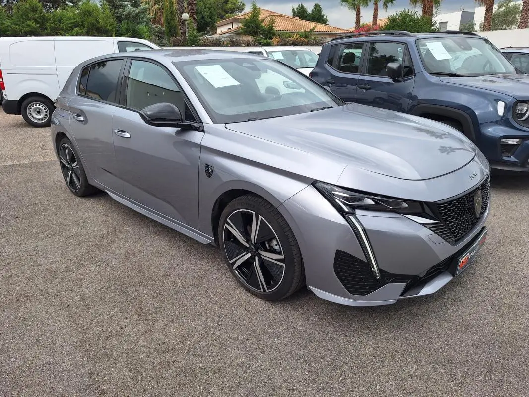 Peugeot 308 Hybrid gris vue 3/4 avant droit, jantes alliage 18 pouces et signature lumineuse LED distinctive.