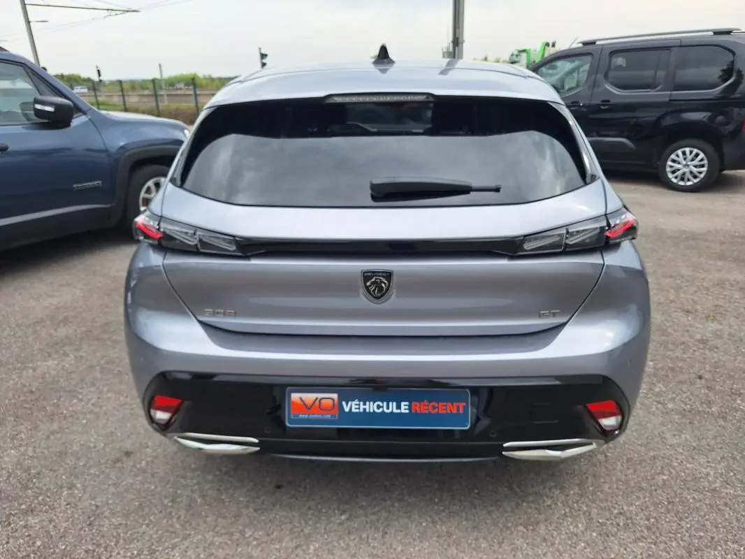 Vue arrière d'une Peugeot 308 gris métallisé 2025 avec feux LED et double sortie d'échappement intégrée.