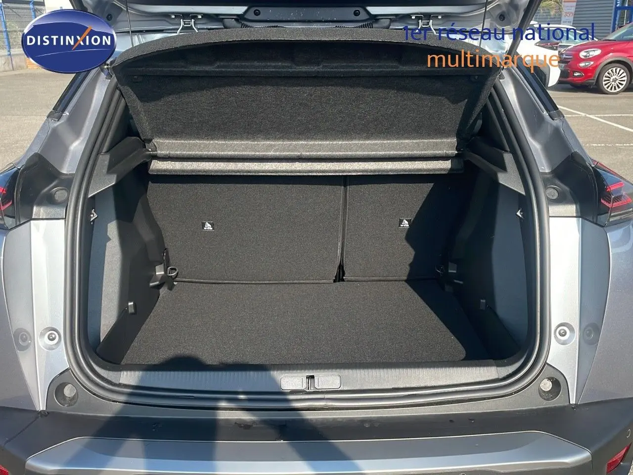 Coffre ouvert vu de l'arrière d'un Peugeot 2008 gris Artense Métal, mettant en valeur son espace de chargement.