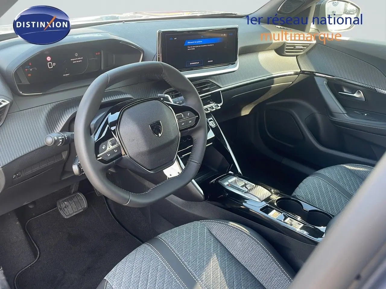 Intérieur avant droit du Peugeot 2008 Hybrid 136ch Allure 2025 avec volant compact et sellerie tissu gris.