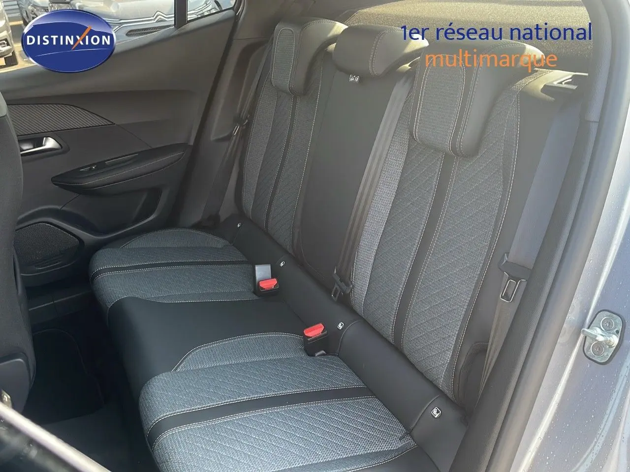 Vue intérieure arrière côté droit du Peugeot 2008 gris Artense Métal, montrant les sièges arrière en tissu et cuir bi-ton.