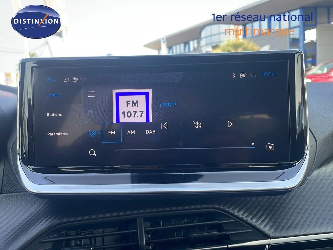 Écran tactile central affichant la radio FM 107.7 dans l'habitacle du Peugeot 2008 gris Artense 2025.