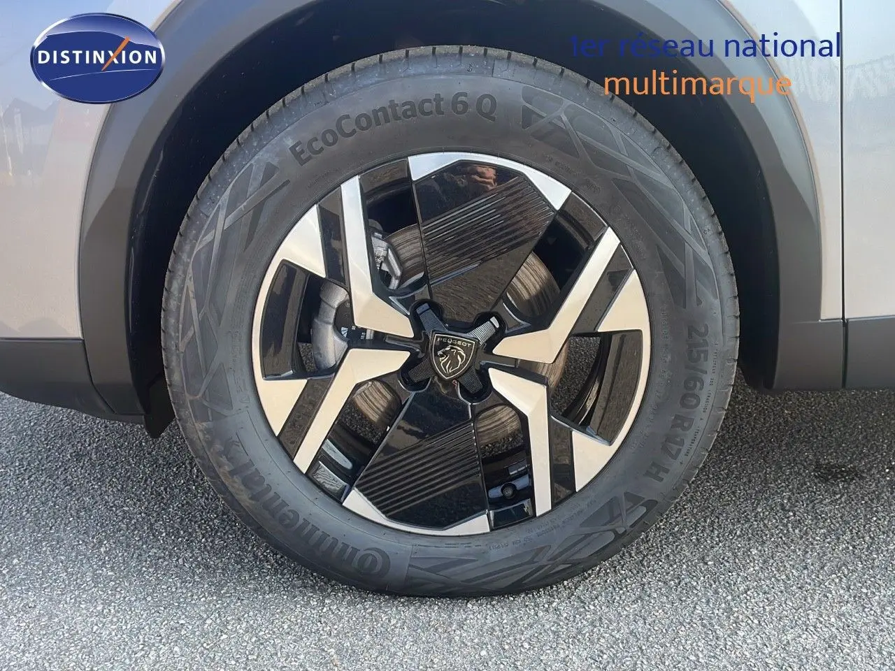 Gros plan sur la roue avant gauche du Peugeot 2008 gris Artense Metal avec jante alliage bicolore distinctive.