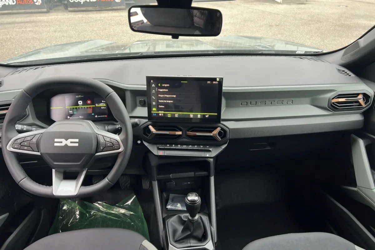 Intérieur du Dacia Duster 2025 kaki lichen, vue de face sur le tableau de bord et la console avec boîte manuelle.