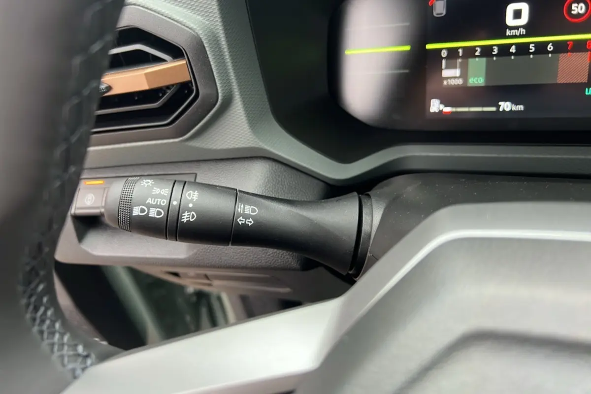 Gros plan sur la commande des feux et clignotants à gauche du volant du Dacia Duster 2025 kaki lichen.
