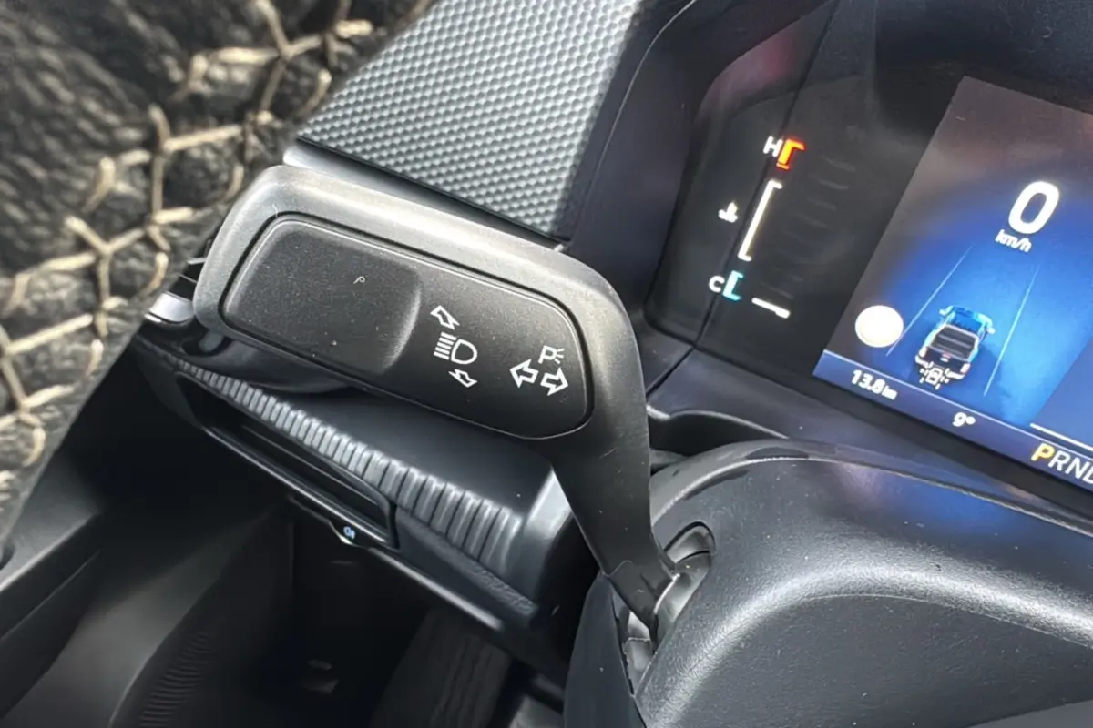 Gros plan sur la manette de clignotant et le tableau de bord numérique du Ford Ranger blanc glacier 2025.
