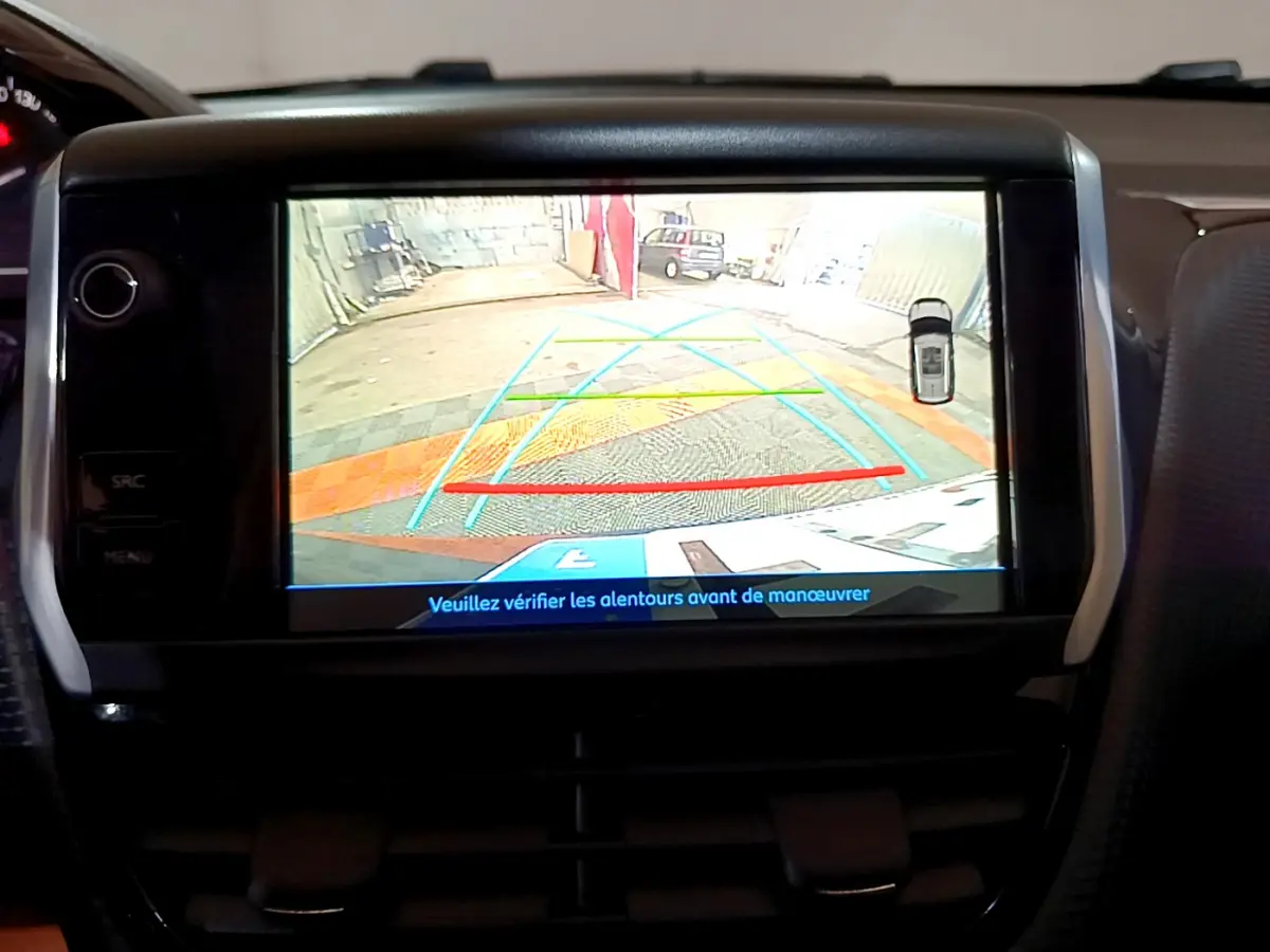Écran tactile intérieur affichant la caméra de recul du Peugeot 2008 gris foncé avec lignes de guidage colorées.