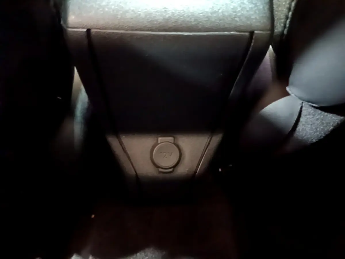 Prise 12V au bas de la console centrale arrière du Peugeot 2008 gris foncé, vue intérieure rapprochée.