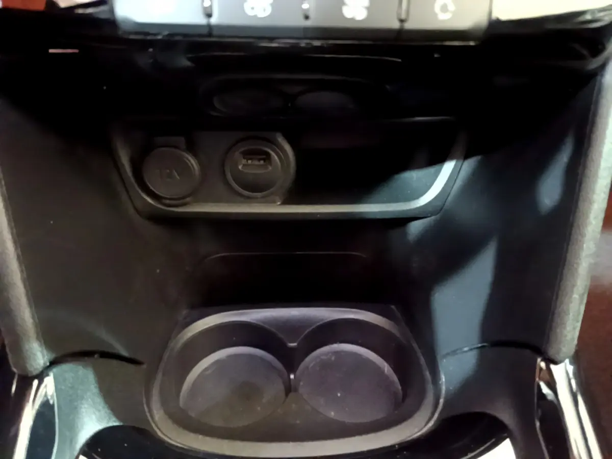 Prise 12V et port USB avec porte-gobelets au centre de la console d'une Peugeot 2008 Crossway gris foncé de 2019.