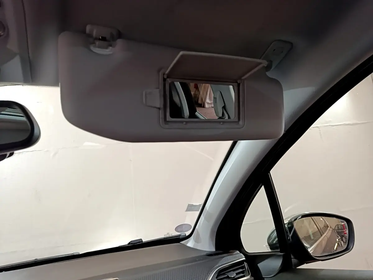 Vue intérieure du pare-soleil côté conducteur avec miroir ouvert dans un Peugeot 2008 gris foncé de 2019.