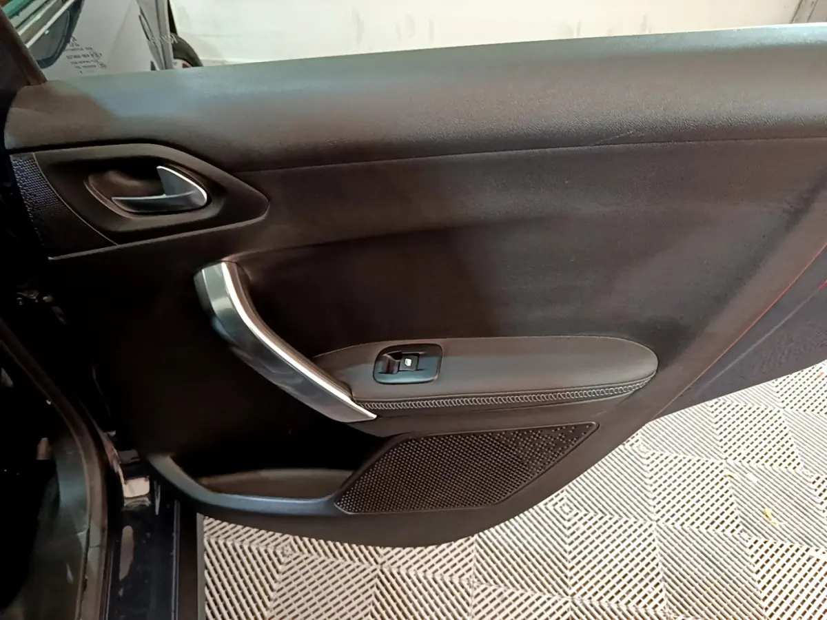 Vue rapprochée de la porte côté gauche noire du Peugeot 2008 Crossway 2019 avec poignée argentée et commande de vitre.