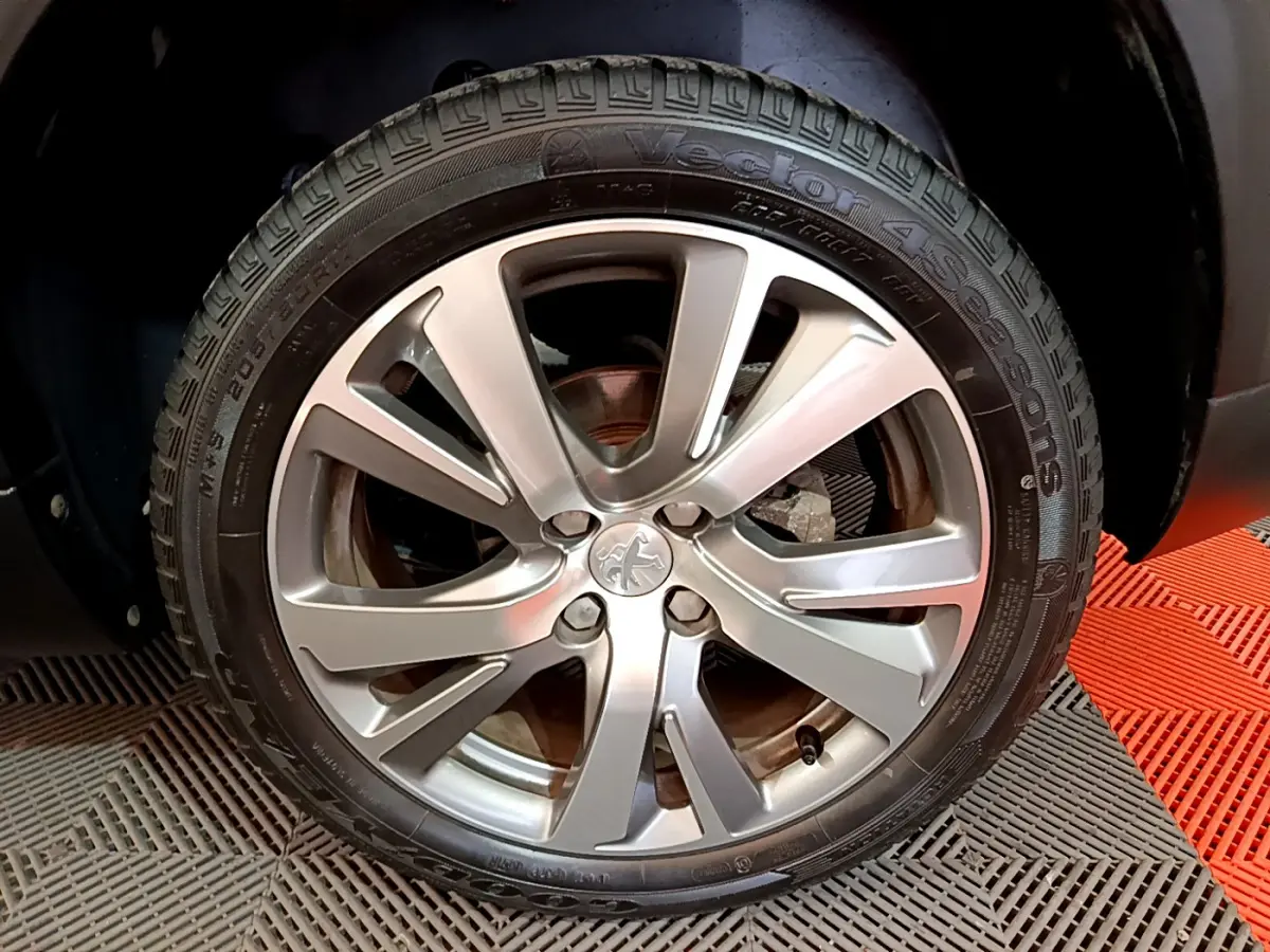 Gros plan sur la roue arrière droite du Peugeot 2008 gris foncé, montrant le pneu et l'arche de roue.