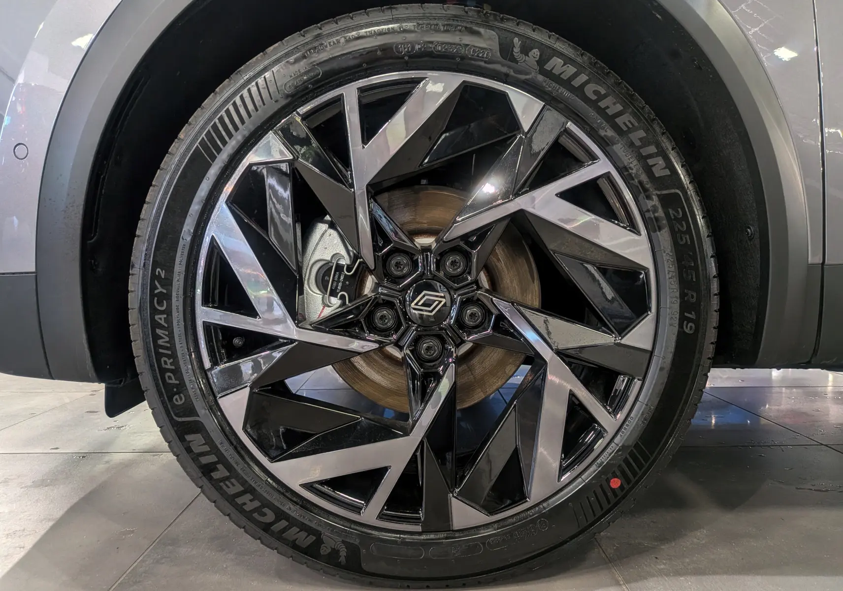 Gros plan sur la roue avant droite de la Renault SYMBIOZ gris Cassiopé, avec jante noire et argentée au design géométrique.