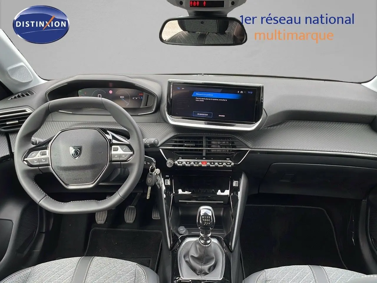 Intérieur de la Peugeot 208 2024 noir Perla Metal, vue frontale du tableau de bord avec boîte manuelle et écran tactile.