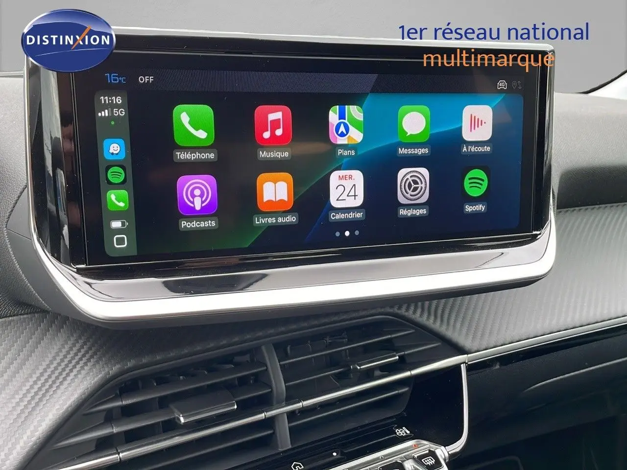 Écran tactile central affichant des applications multimédia dans l'habitacle d'une Peugeot 208 noire 2024.