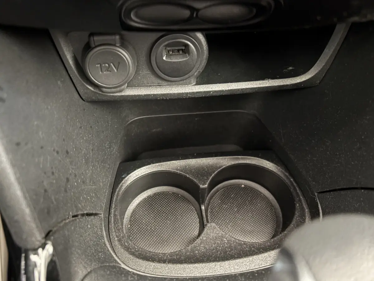 Prise 12V et port USB au-dessus des porte-gobelets noirs dans l'habitacle du Peugeot 2008 Puretech 2019.