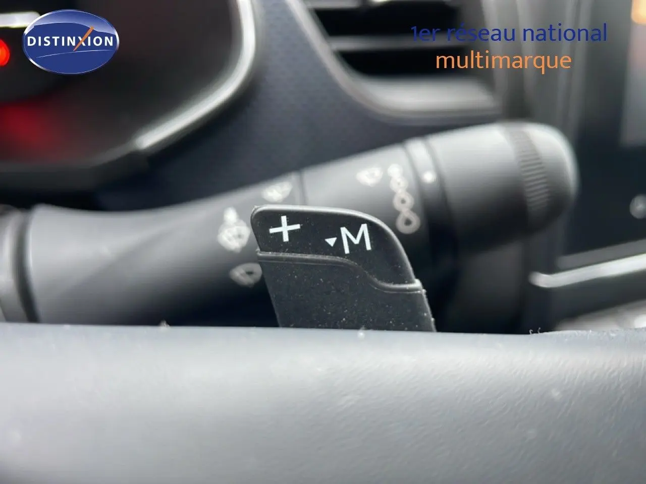 Gros plan sur la palette de passage de vitesses +M du volant d’une Renault Arkana bleu Zanzibar 2025.