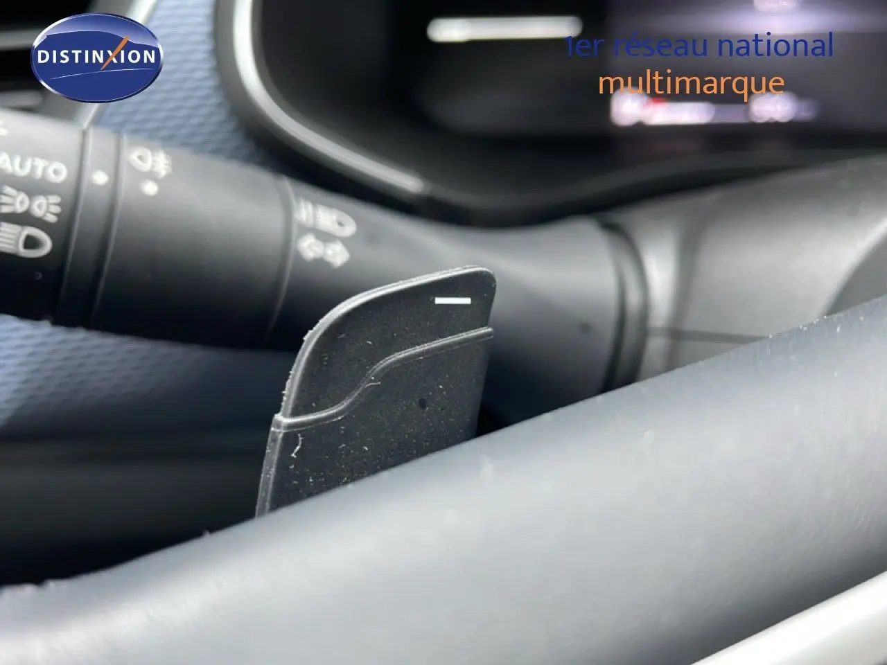 Gros plan sur la palette de changement de vitesse derrière le volant d’un Renault Arkana bleu Zanzibar 2025.